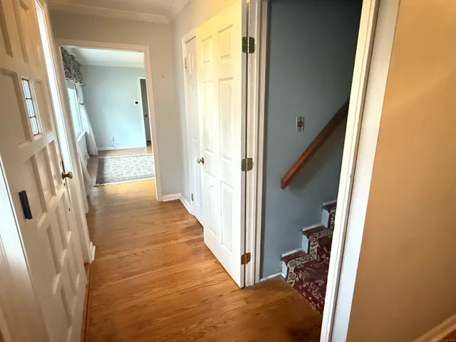a view of a hallway with wooden floor and staircase