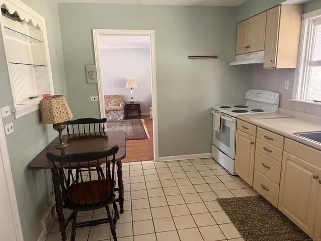 a kitchen with a sink chairs and cabinets