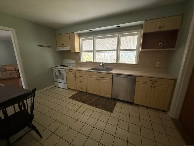 a large kitchen with a sink a stove and a window