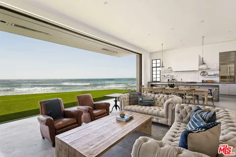 a living room with furniture and floor to ceiling window