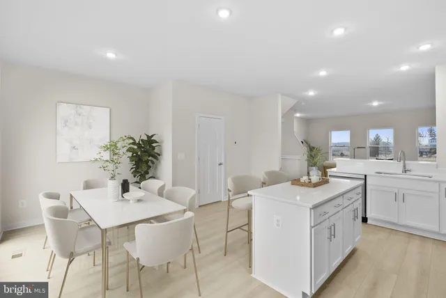 a kitchen that has a sink a table and chairs in it