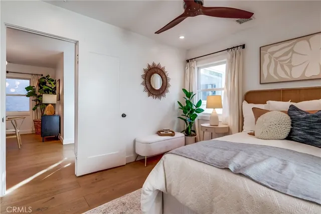 a bedroom with a bed a chandelier and a window