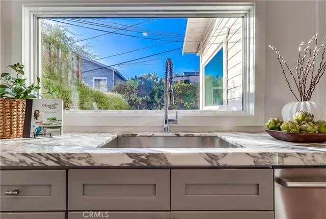 a kitchen with granite countertop a sink and a white wooden cabinets