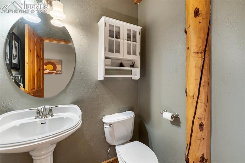 9110 Mountain Road Cascade, CO 80809 - Photo 12 of 49 a bathroom with a toilet sink and mirror