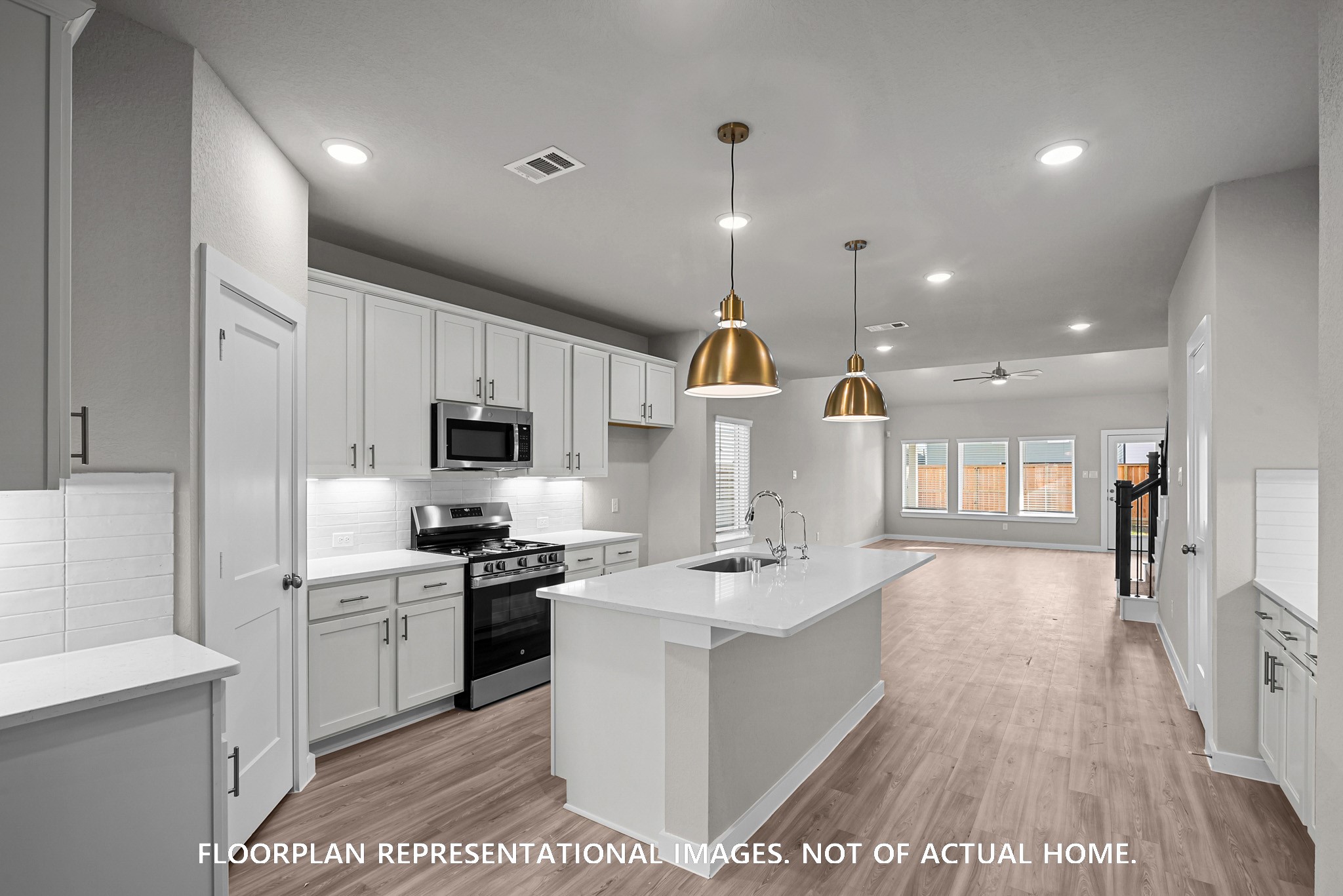 8311 Blue Shell Lane Cypress, TX 77433 - Photo 9 of 22 a open kitchen with kitchen island a sink stove and wooden floor