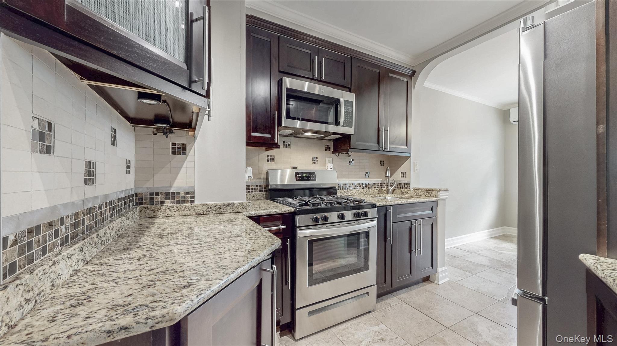 67-04 Selfridge Street, Unit 2 Queens, NY 11375 - Photo 11 of 21 a kitchen with stainless steel appliances granite countertop a stove and a refrigerator