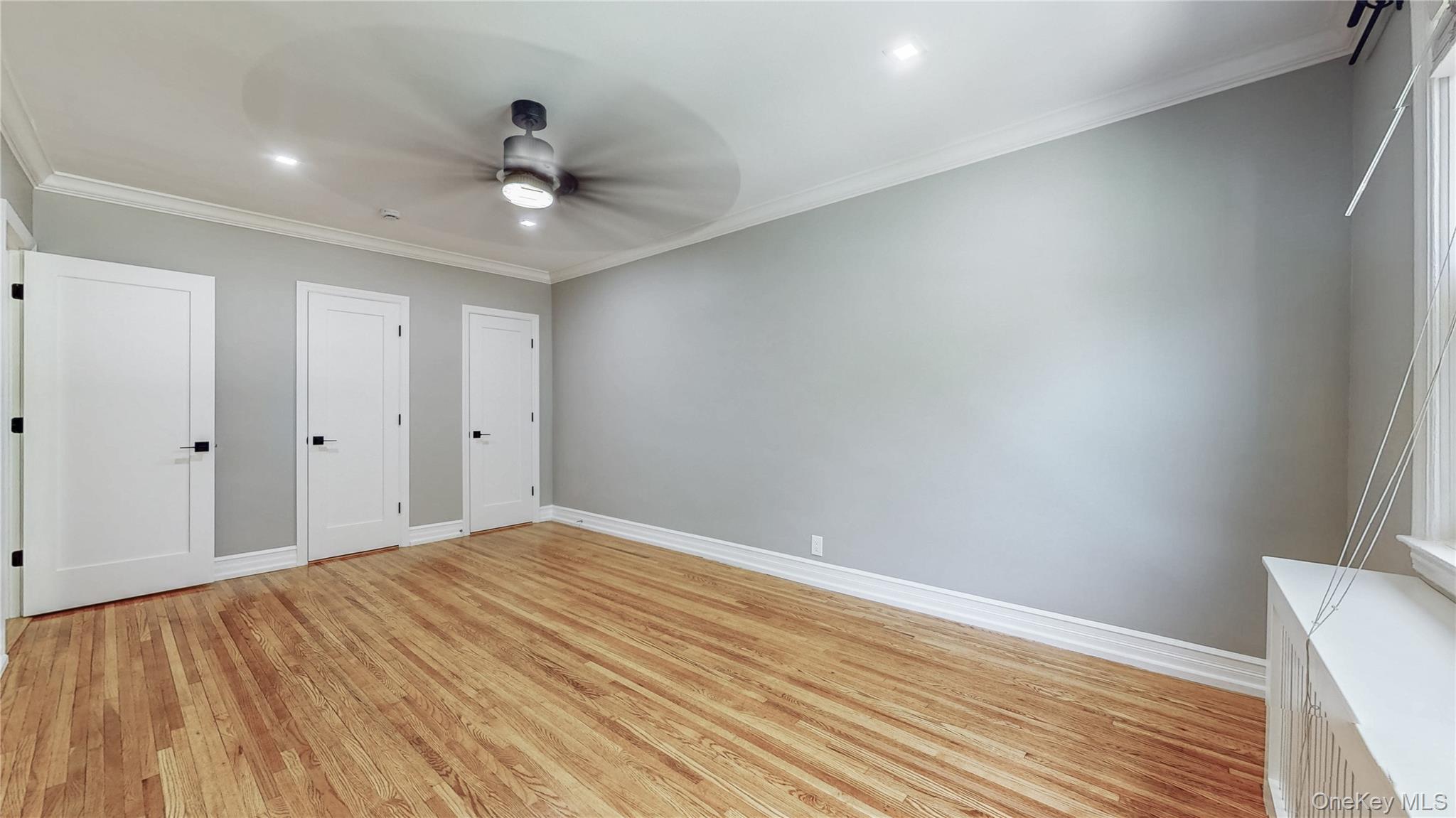 67-04 Selfridge Street, Unit 2 Queens, NY 11375 - Photo 16 of 21 a view of a room with wooden floor and ceiling fan