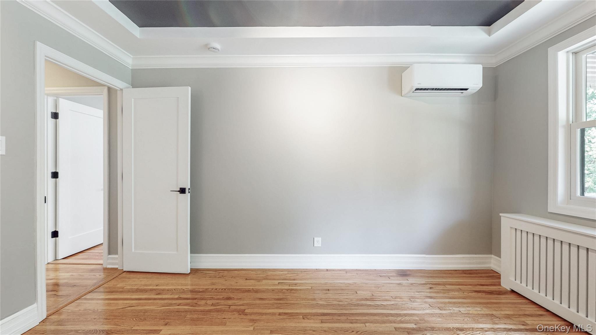 67-04 Selfridge Street, Unit 2 Queens, NY 11375 - Photo 18 of 21 a view of an empty room with wooden floor and a window
