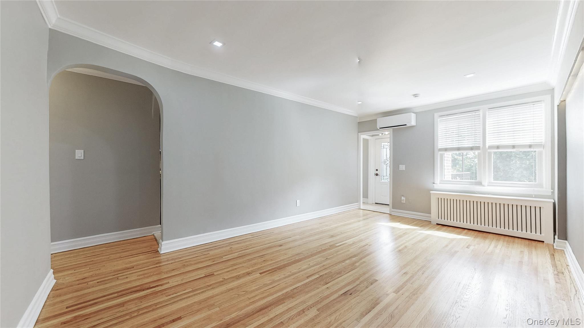 67-04 Selfridge Street, Unit 2 Queens, NY 11375 - Photo 6 of 21 an empty room with wooden floor and windows
