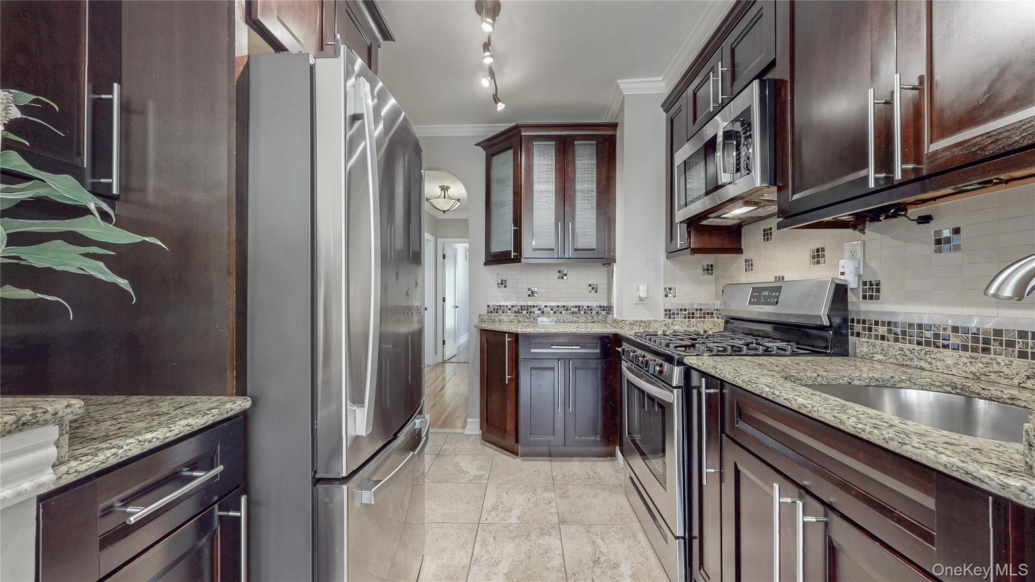 67-04 Selfridge Street, Unit 2 Queens, NY 11375 - Photo 9 of 21 a kitchen with stainless steel appliances granite countertop a refrigerator a stove and a sink