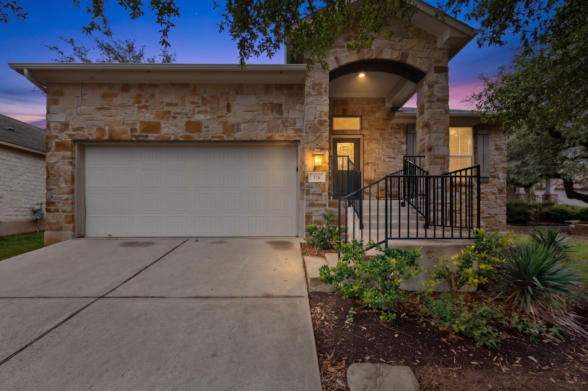 178 Limestone Trail Austin, TX 78737 - Photo 5 of 40 Stone exterior featuring an arched portico entry with black wrought iron railings
