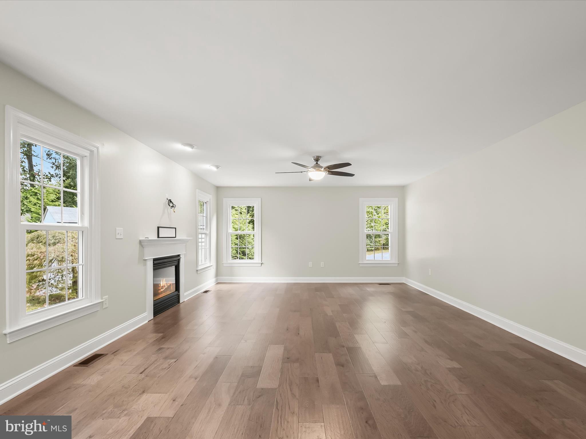 3720 Buffalo Road New Windsor, MD 21776 - Photo 22 of 115 an empty room with windows fireplace and wooden floor