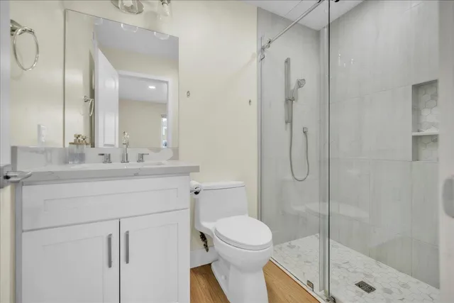 a bathroom with a shower sink vanity mirror and toilet