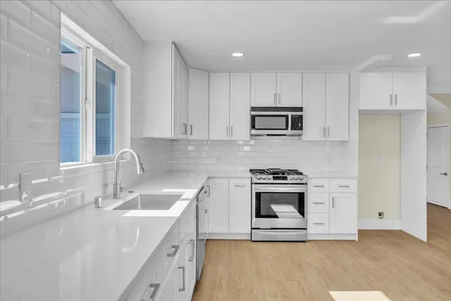 a kitchen with stainless steel appliances granite countertop a sink stove and refrigerator