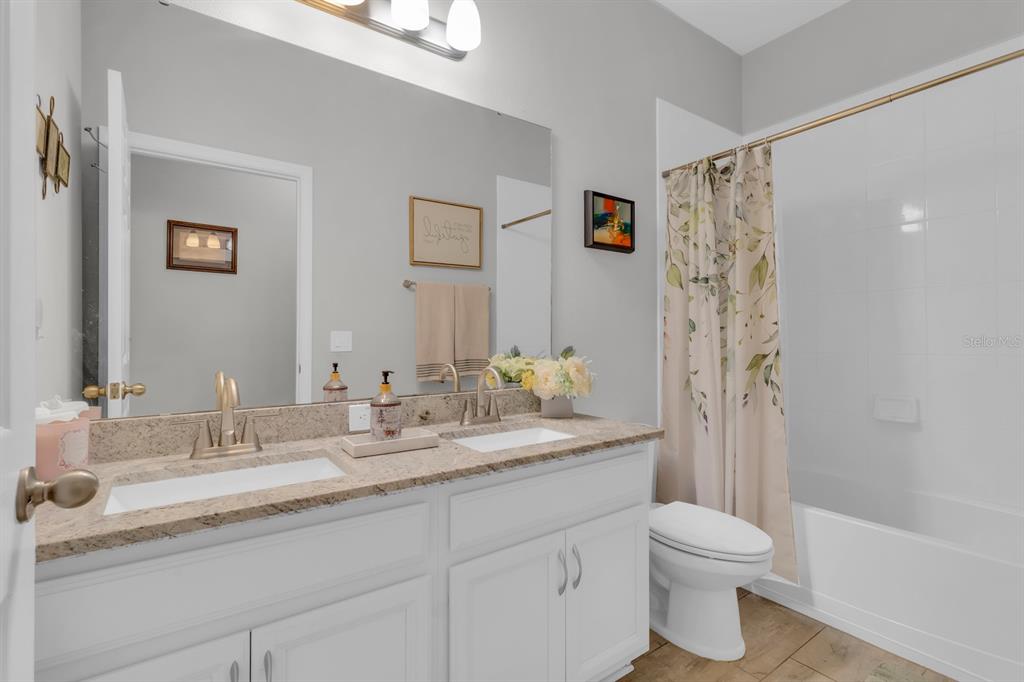 3468 Middlebrook Place St. Cloud, FL 34773 - Photo 17 of 32 a bathroom with a granite countertop sink toilet and shower
