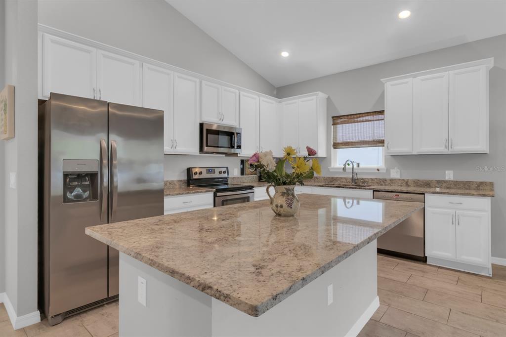 3468 Middlebrook Place St. Cloud, FL 34773 - Photo 6 of 32 a kitchen with kitchen island a counter top space cabinets and stainless steel appliances