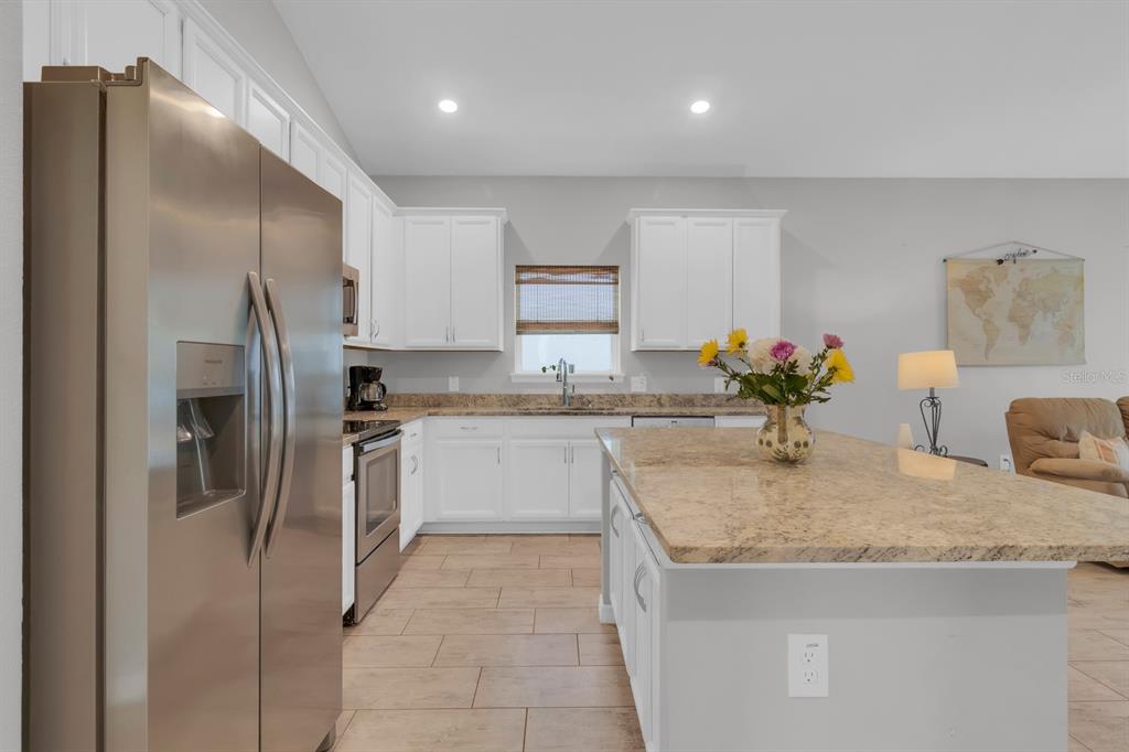 3468 Middlebrook Place St. Cloud, FL 34773 - Photo 7 of 32 a kitchen with stainless steel appliances granite countertop a sink a refrigerator and a granite counter tops