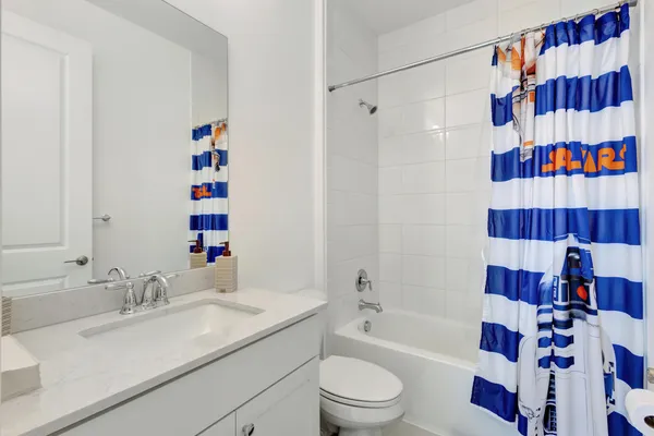 a bathroom with a sink a toilet and a shower curtain