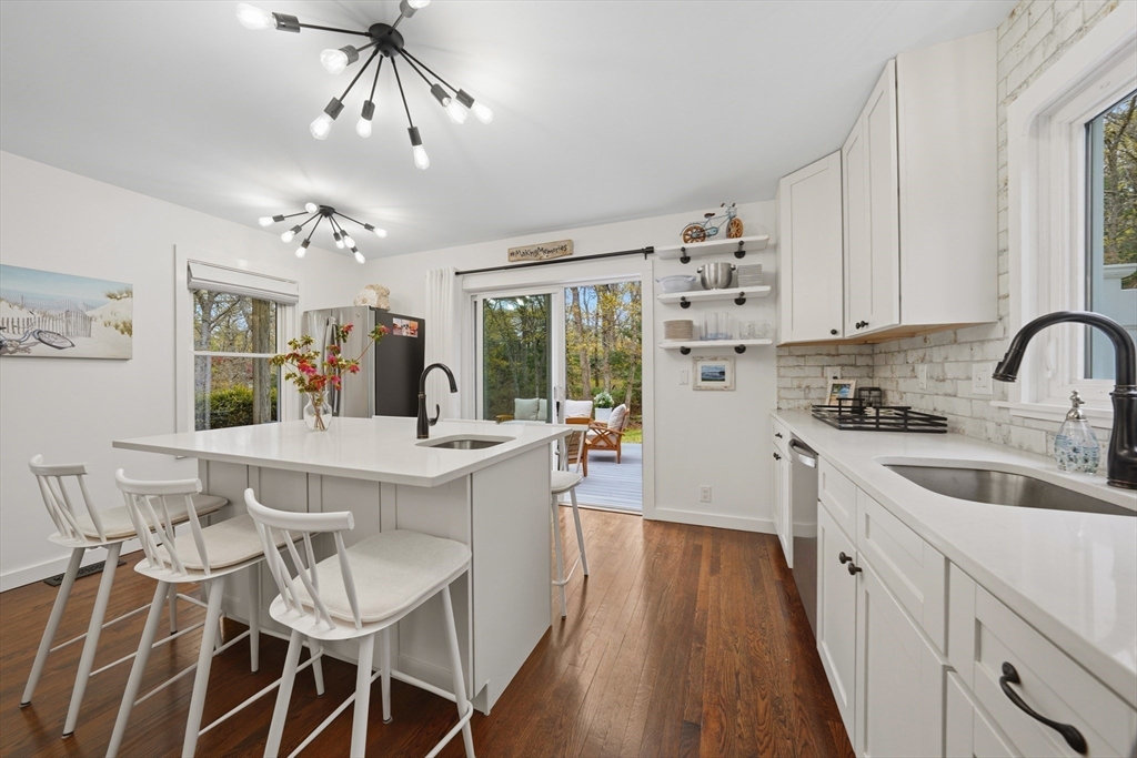 55 Ridgeview Drive Falmouth, MA 02540 - Photo 16 of 32 a kitchen with a dining table chairs sink and cabinets