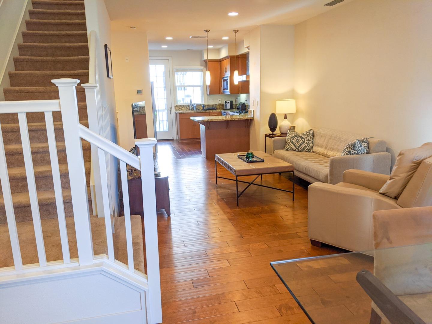 2912 Shoemaker Dr. San Mateo, CA 94403 - Photo 11 of 27 a living room with couches and kitchen view with wooden floor