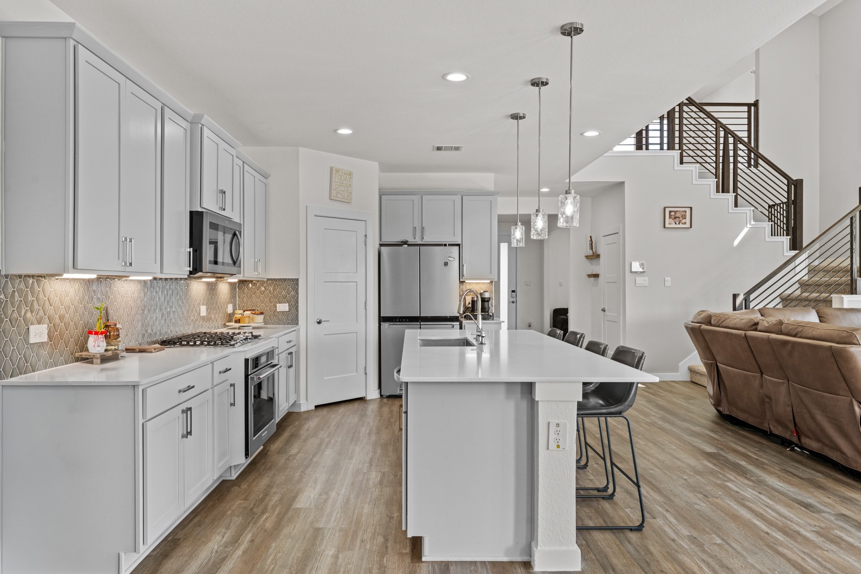 22503 Modica Rift Lane Katy, TX 77449 - Photo 15 of 42 a large kitchen with stainless steel appliances kitchen island granite countertop a stove a sink a refrigerator and white cabinets with wooden floor