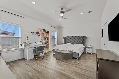 a spacious bedroom with a bed and a flat screen tv