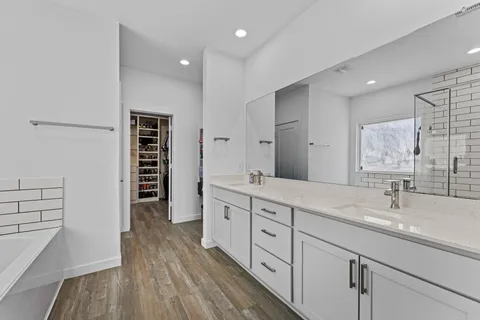 a spacious bathroom with a shower a sink and a large mirror