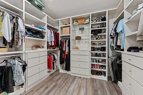 a view of walk in closet with clothes and shoes