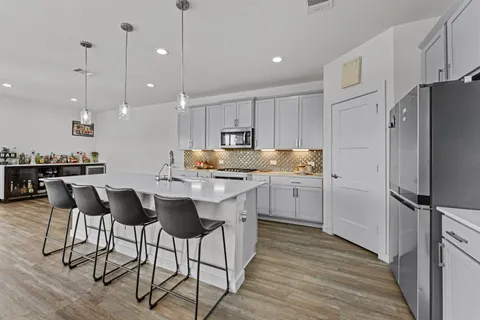 a kitchen with a refrigerator a sink and white cabinets