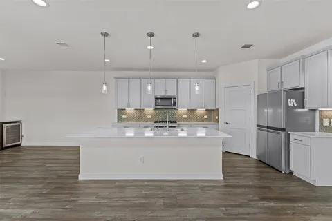 a view of kitchen with stainless steel appliances granite countertop a stove a refrigerator and a sink