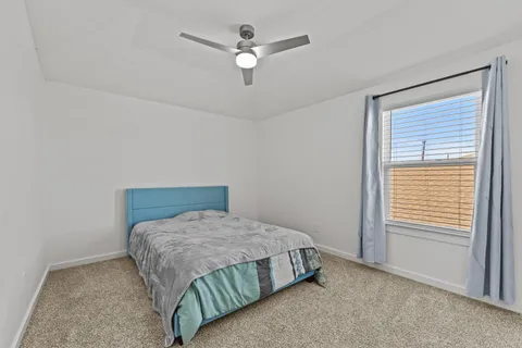 a bedroom with a bed and a ceiling fan