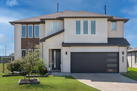 a front view of a house with a yard and garage