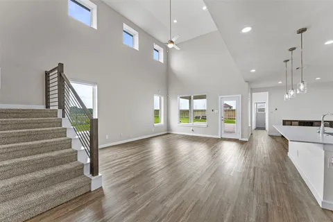 a view of a room with wooden floors and kitchen view
