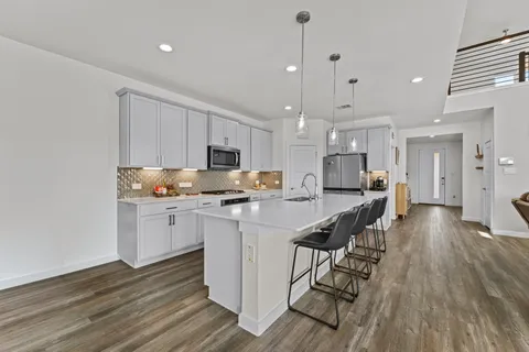a kitchen with stainless steel appliances kitchen island granite countertop a sink and cabinets