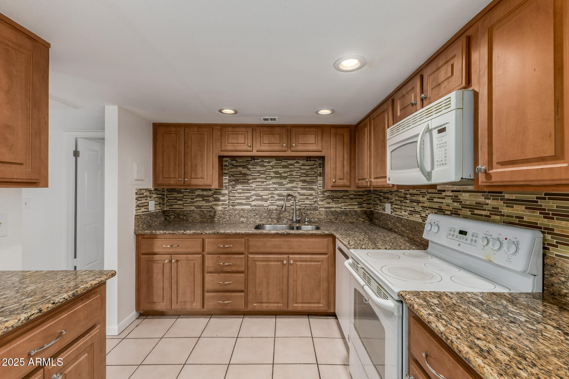 5136 North 31st Place, Unit 634 Phoenix, AZ 85016 - Photo 12 of 45 a kitchen with a sink stove top oven and cabinets