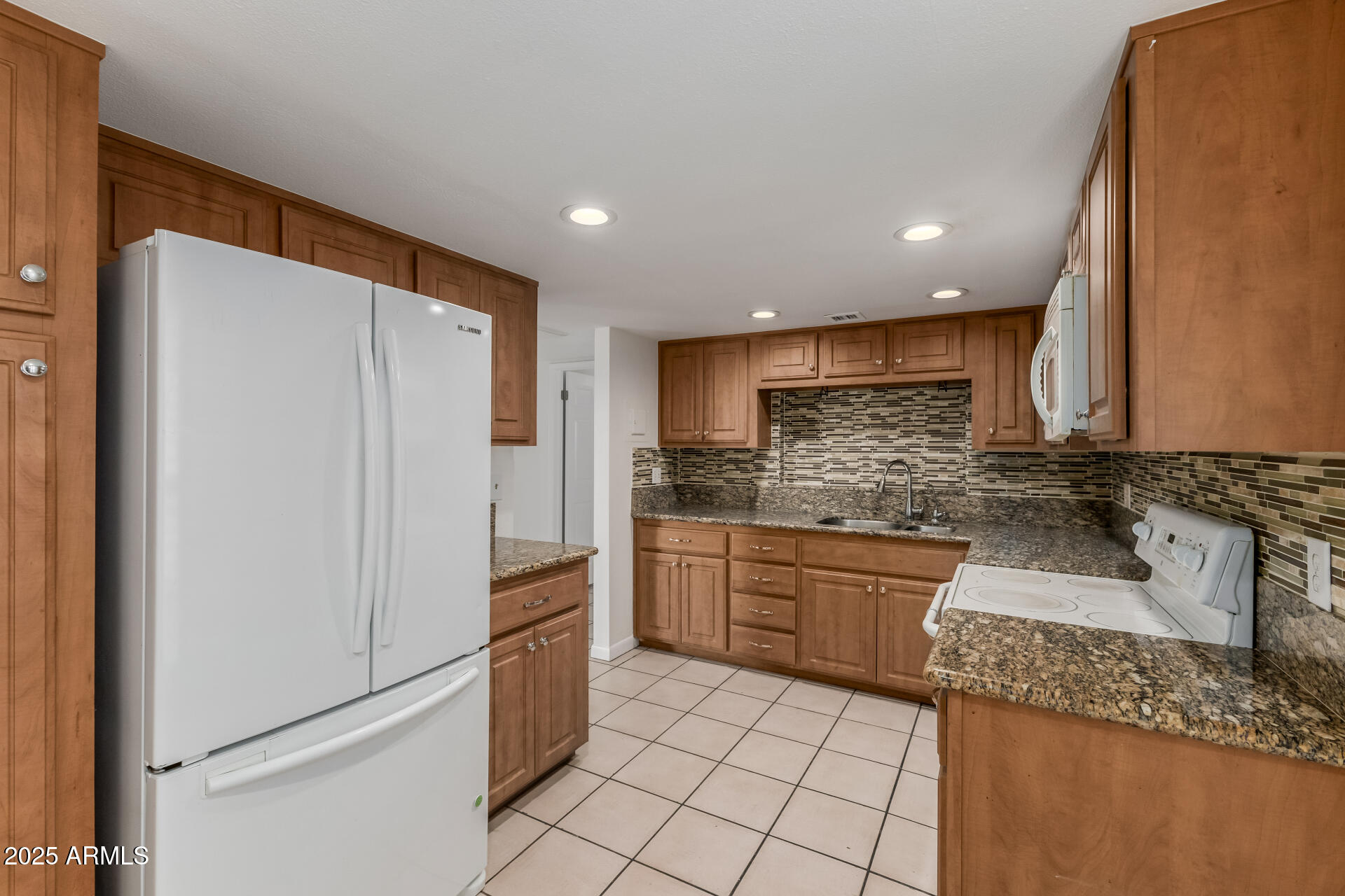 5136 North 31st Place, Unit 634 Phoenix, AZ 85016 - Photo 14 of 45 a kitchen with a refrigerator sink and cabinets