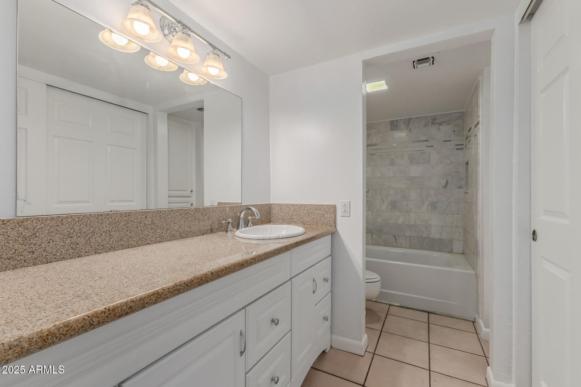 5136 North 31st Place, Unit 634 Phoenix, AZ 85016 - Photo 16 of 45 a bathroom with a granite countertop sink a toilet and shower