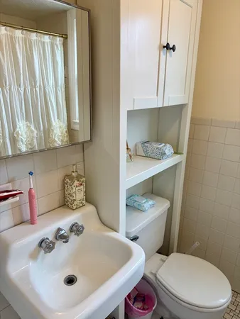 a bathroom with a sink a toilet and mirror