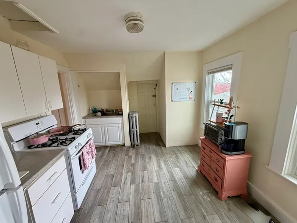a kitchen with a stove and wooden floor