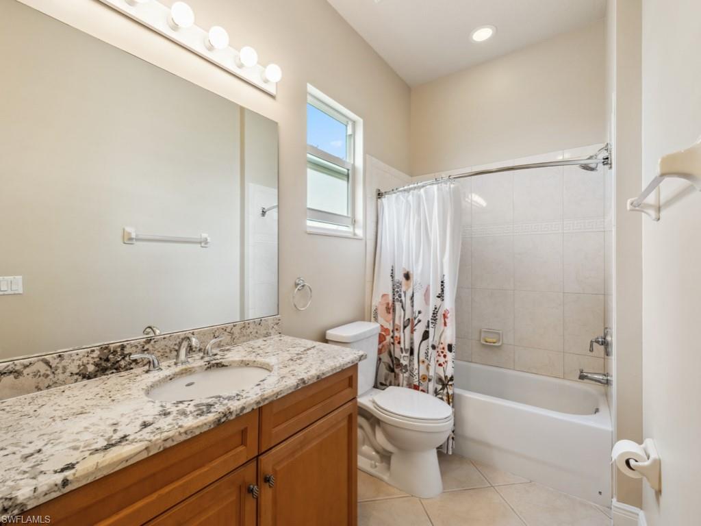 5705 Mango Circle Naples, FL 34110 - Photo 13 of 48 a bathroom with a granite countertop sink toilet and shower