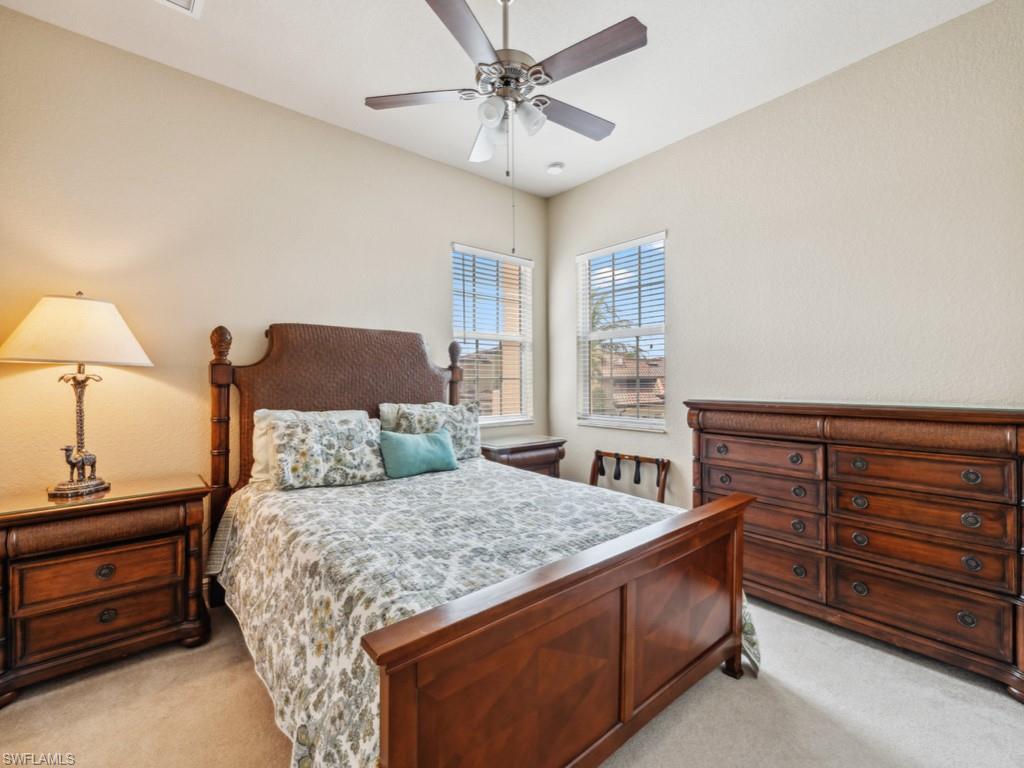 5705 Mango Circle Naples, FL 34110 - Photo 14 of 48 a bedroom with a bed and a chandelier