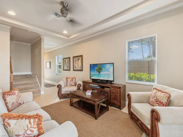 a living room with furniture a flat screen tv and a window