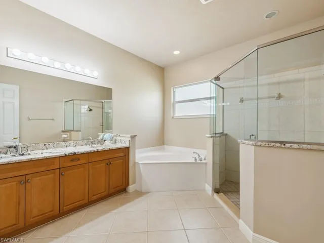 a bathroom with a tub sink shower and mirror