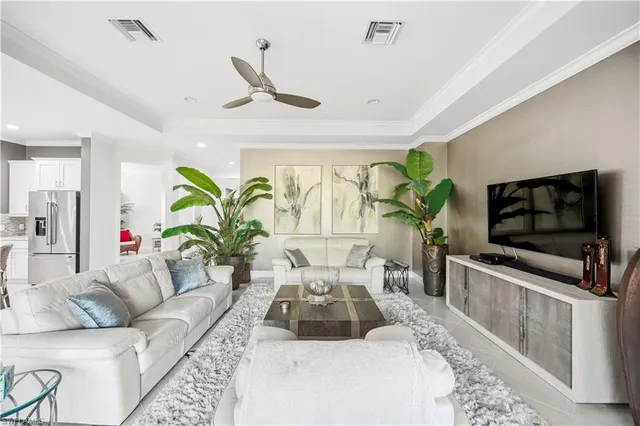 a living room with furniture kitchen and a chandelier
