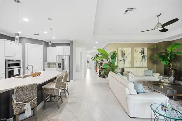 a kitchen with a dining table chairs refrigerator and microwave