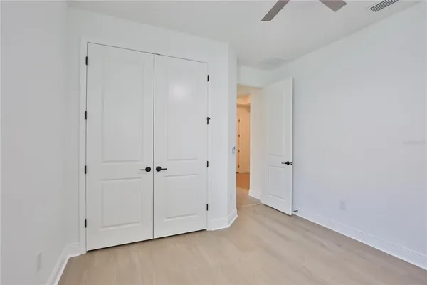 an empty room with a window and a fan