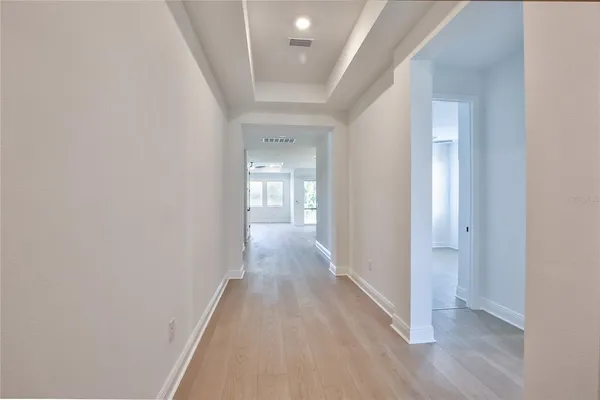 a view of a hallway with wooden floor