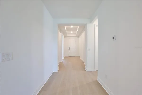 a view of a hallway with wooden floor and a window