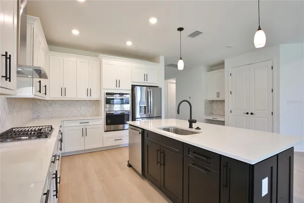 a kitchen with kitchen island a sink stainless steel appliances and cabinets