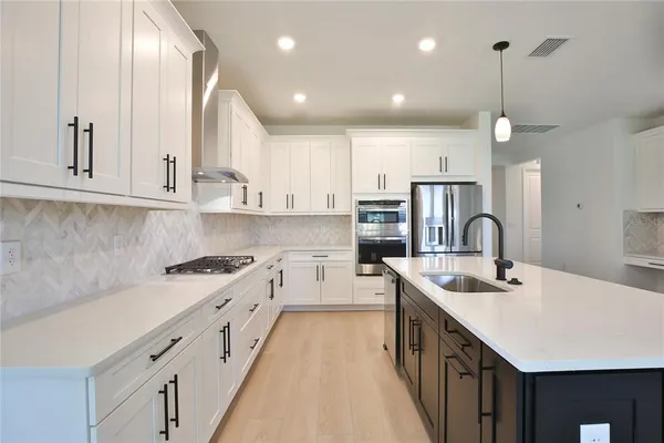 a kitchen with counter top space a sink and appliances